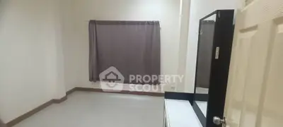 Spacious bedroom with large window and neutral decor, perfect for customization.