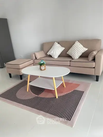 Modern living room with stylish beige sofa, chic coffee table, and elegant decor on a sleek rug.