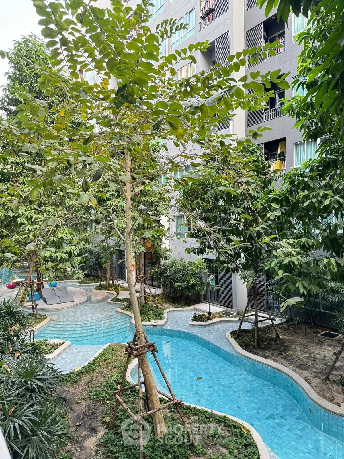 Lush garden view with winding pool in modern residential complex