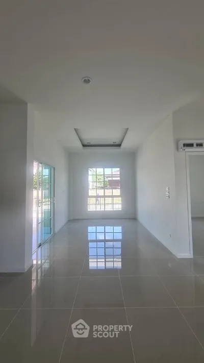 Spacious empty room with glossy tiled floor and large window view