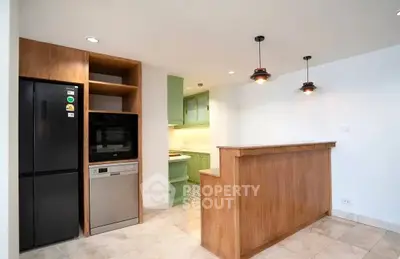 Modern kitchen with open layout, featuring sleek appliances and stylish lighting.
