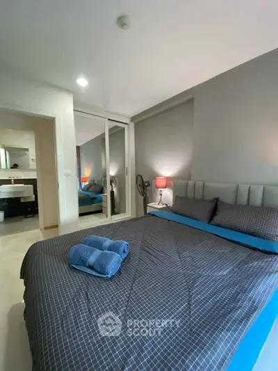 Cozy bedroom with modern decor and mirrored wardrobe in stylish apartment.