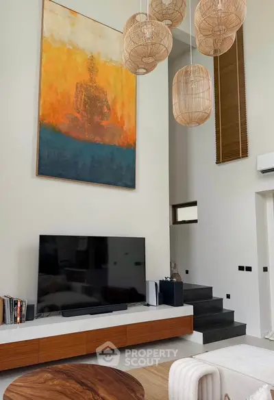 Modern living room with high ceilings, stylish pendant lights, and contemporary art.