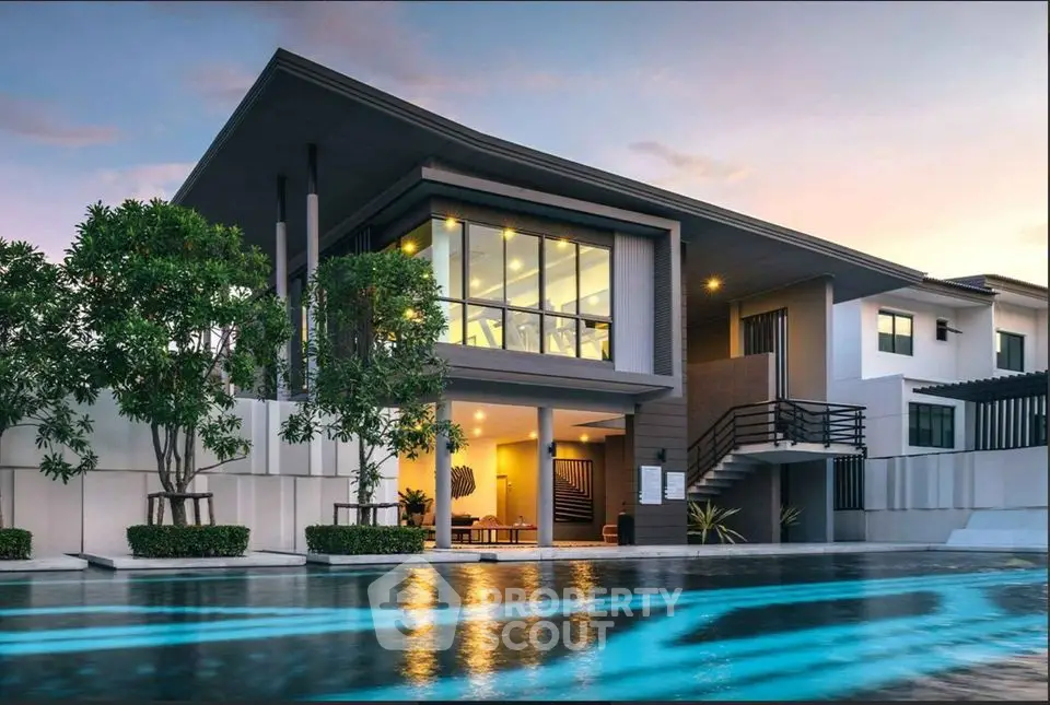 Luxurious modern home with stunning pool and elegant architecture at sunset.