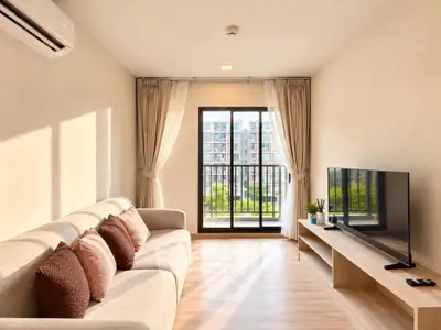 Bright living room with modern decor and balcony view in a stylish apartment.