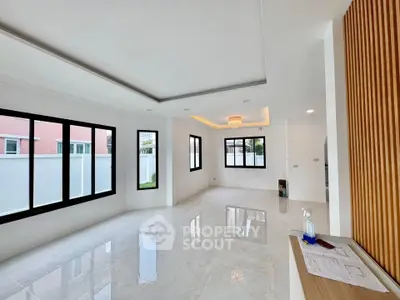 Spacious modern living room with large windows and elegant ceiling lighting