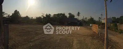 Expansive land plot with potential for development, surrounded by lush greenery and rural charm.