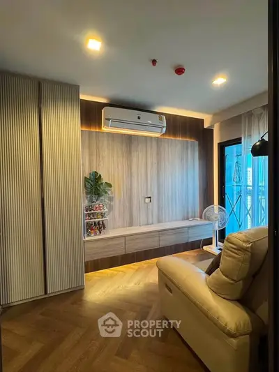 Modern living room with sleek design, featuring built-in storage and air conditioning, perfect for urban living.