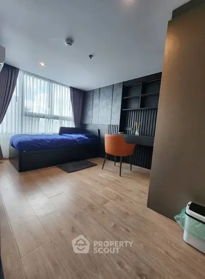 Modern bedroom with wooden flooring, large window, and built-in shelving unit.