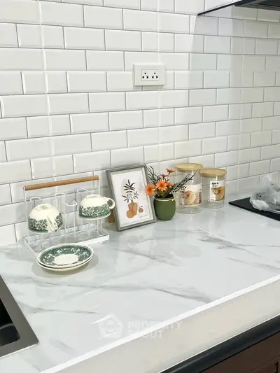 Modern kitchen countertop with elegant decor and white subway tile backsplash.