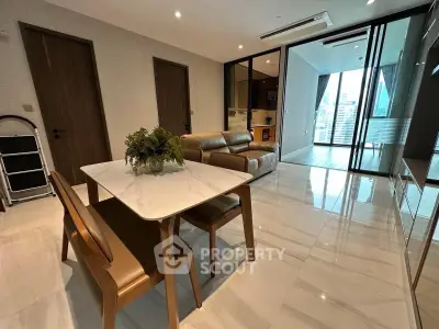 Modern open-plan living room with sleek furniture and city view balcony.