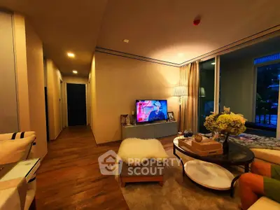 Cozy living room with modern decor and warm lighting, featuring a TV and stylish furniture.