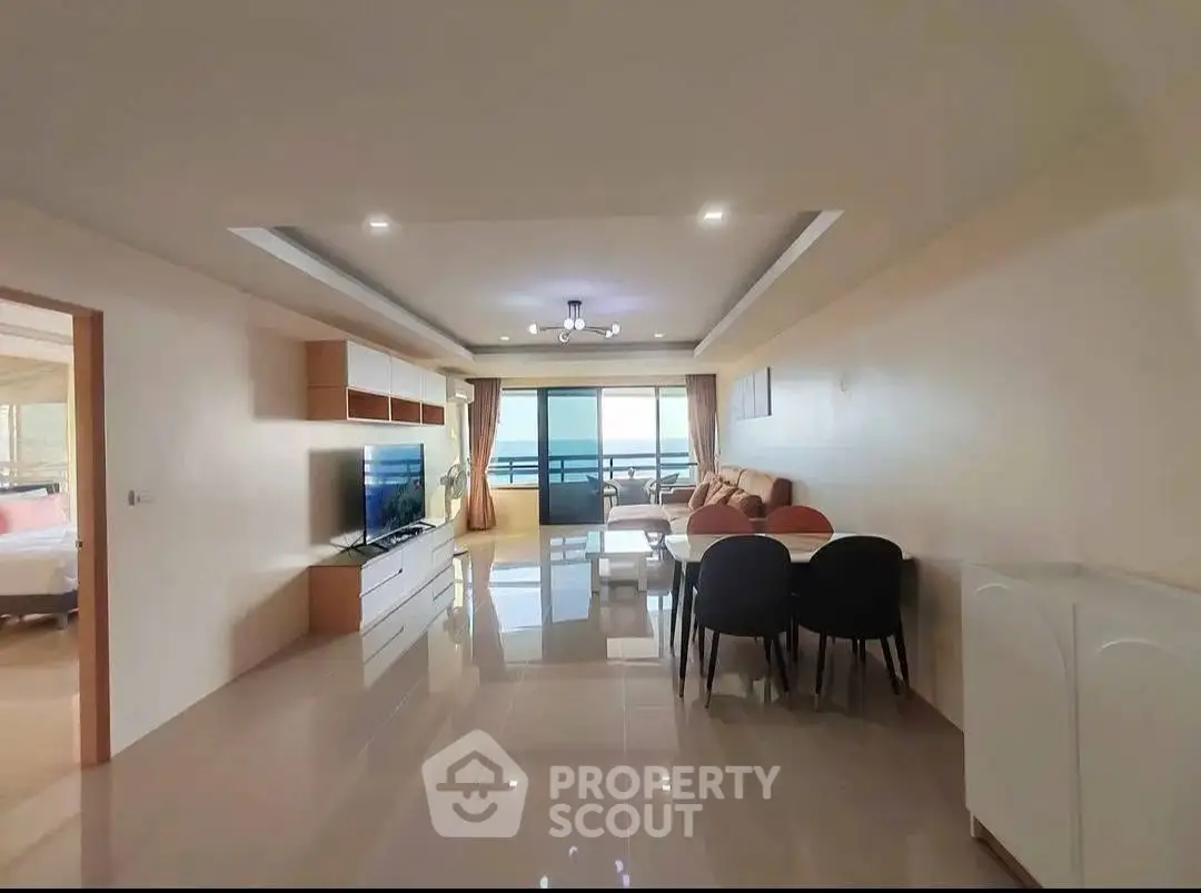 Spacious living room with modern decor and balcony view, perfect for relaxation and entertainment.