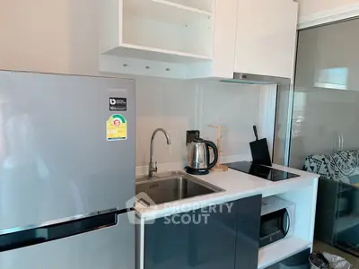 Modern kitchen with sleek appliances and stylish cabinetry in a contemporary apartment.