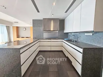 Modern kitchen with sleek white cabinets and granite countertops in open layout