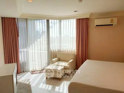 Bright and airy bedroom with large windows and modern furnishings in a stylish apartment.