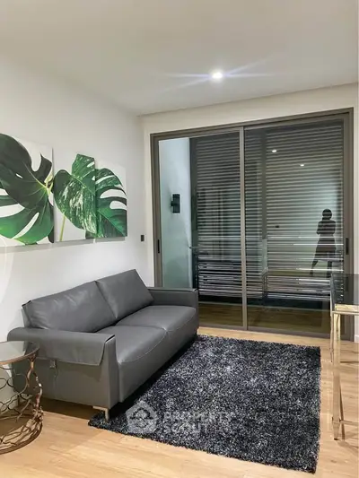 Modern living room with sleek gray sofa, stylish decor, and large sliding glass doors.