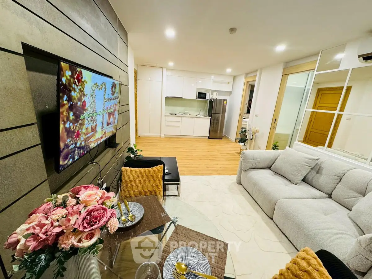Modern living room with open kitchen, stylish decor, and cozy seating area
