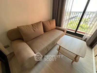 Cozy living room with modern sofa and wooden coffee table near a bright window view.