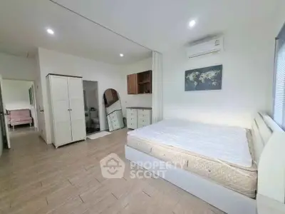 Spacious bedroom with modern decor and ample natural light, featuring a comfortable bed and stylish furnishings.