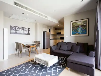 Modern open-plan living room with stylish furniture and kitchen in a contemporary apartment.