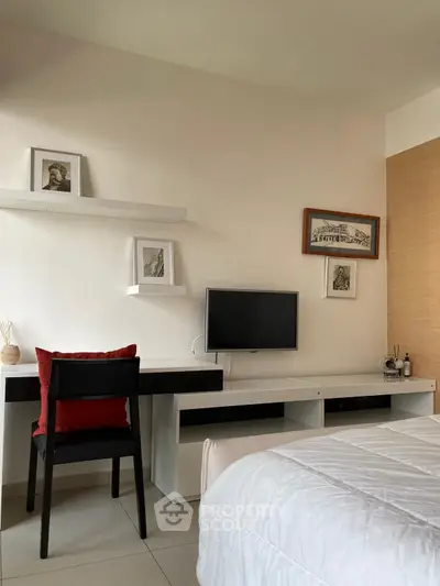 Modern bedroom with sleek desk, wall-mounted TV, and stylish decor.