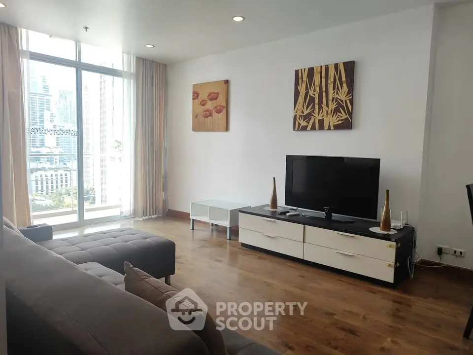 Spacious modern living room with city view, featuring stylish decor and large windows for natural light.