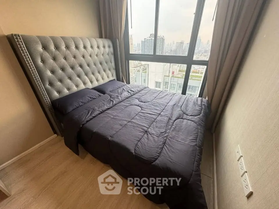 Cozy bedroom with plush headboard and city view from large window