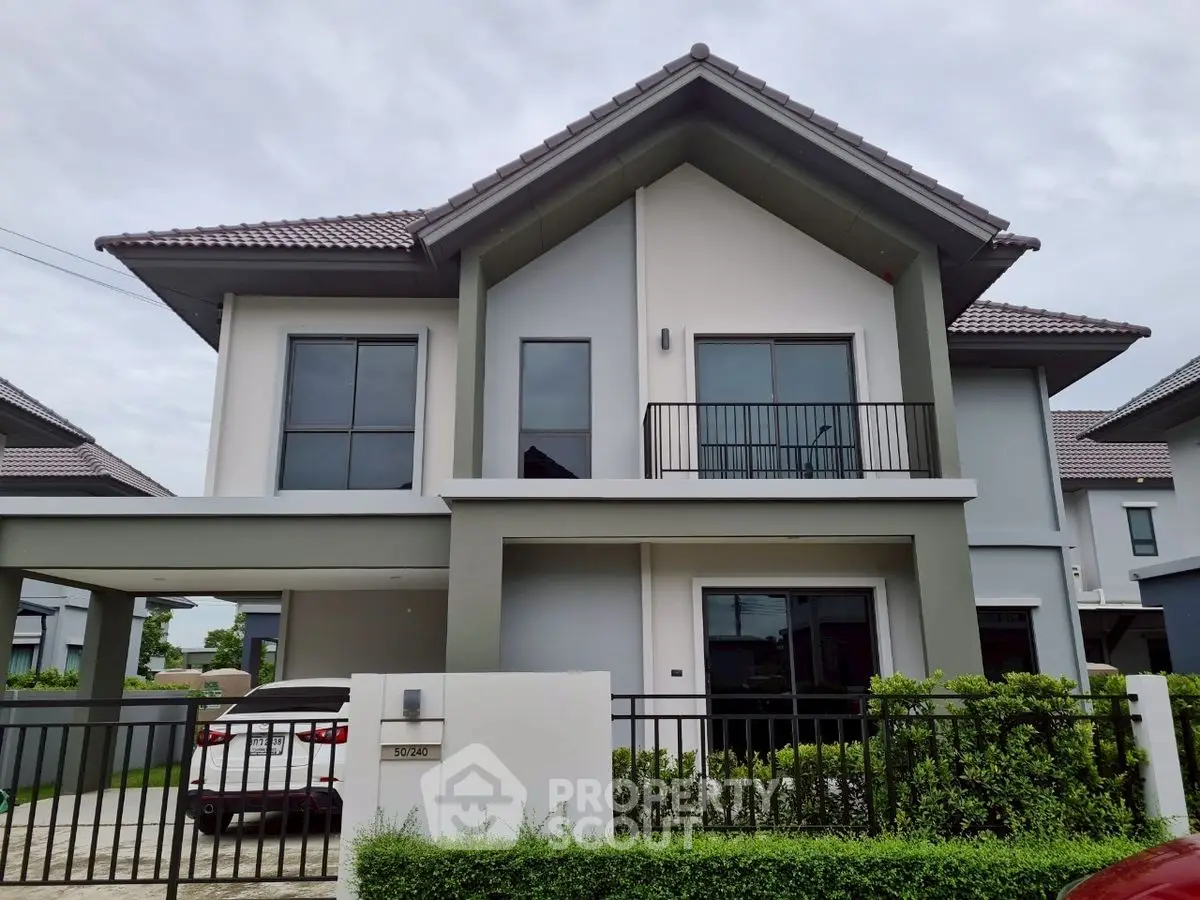Modern two-story house with sleek design and spacious driveway in suburban neighborhood.