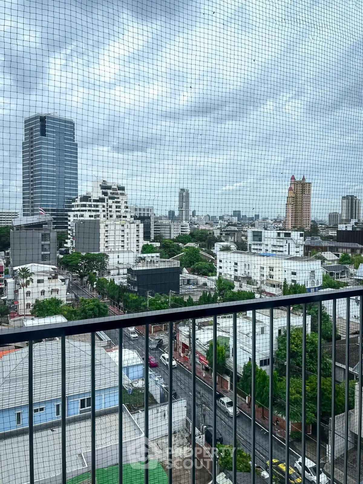 Stunning cityscape view from a high-rise balcony showcasing urban skyline and lush greenery.