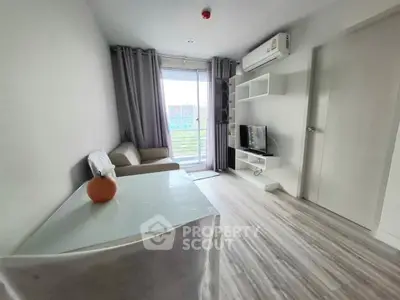 Modern living room with sleek design, featuring a cozy sofa, wall-mounted TV, and large window for natural light.