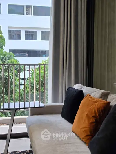 Modern living room with cozy sofa and balcony view, perfect for urban living.
