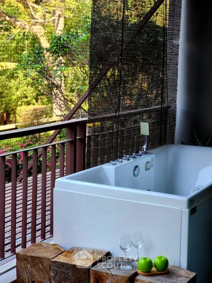 Luxurious balcony with outdoor bathtub and scenic garden view