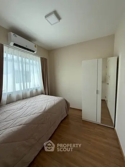 Cozy bedroom with wooden flooring and natural light