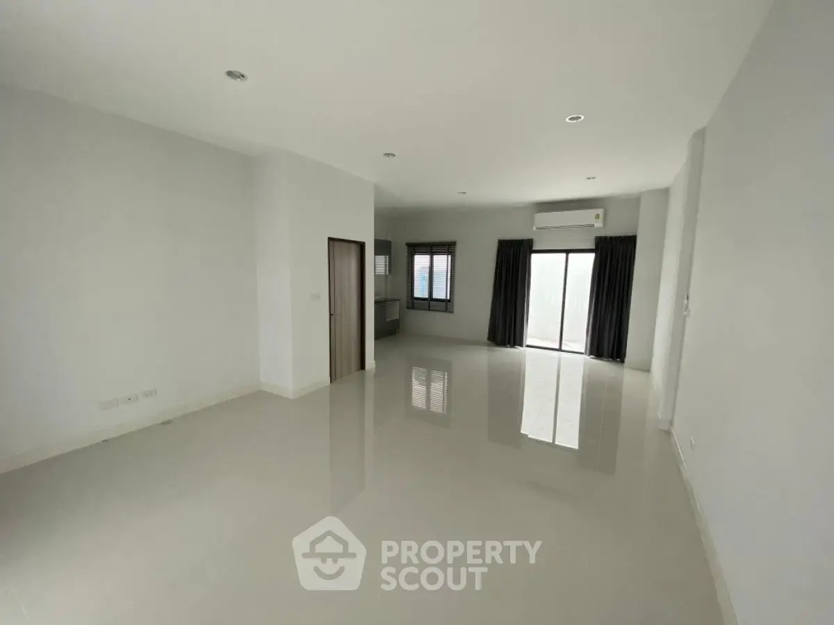 Spacious unfurnished living room with large windows and glossy tiled floor