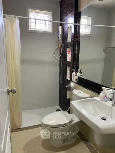 Modern bathroom with shower, sink, and toilet in a compact layout.