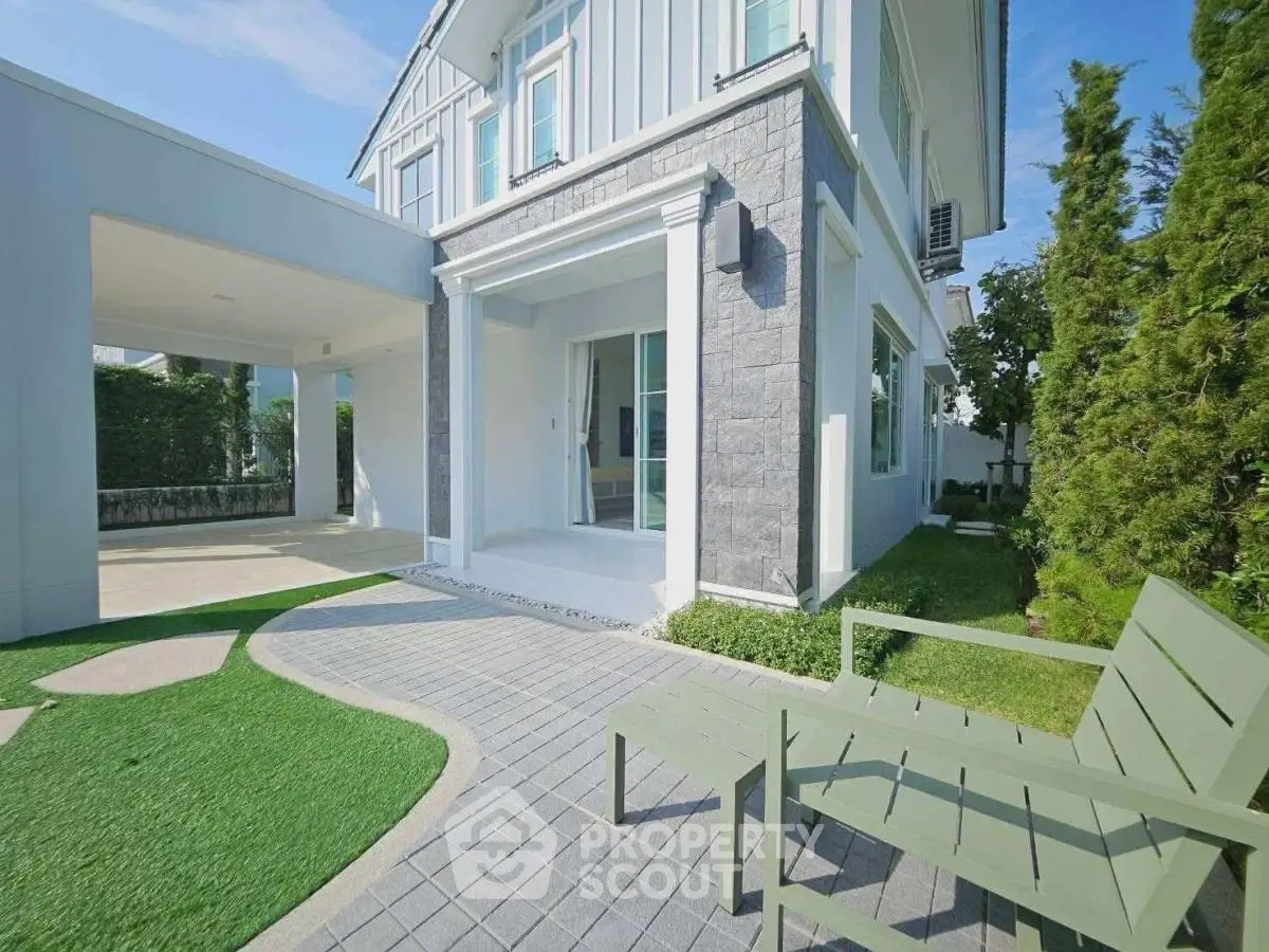 Modern two-story house with landscaped garden and patio seating