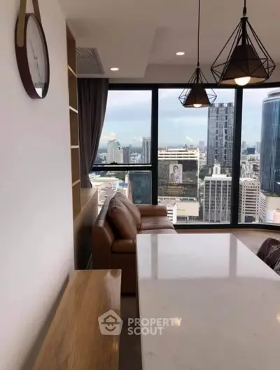 Modern living room with stunning city view and stylish lighting fixtures.