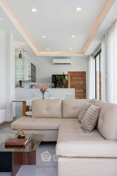 Luxurious modern living room with elegant beige sofa and stylish open kitchen.