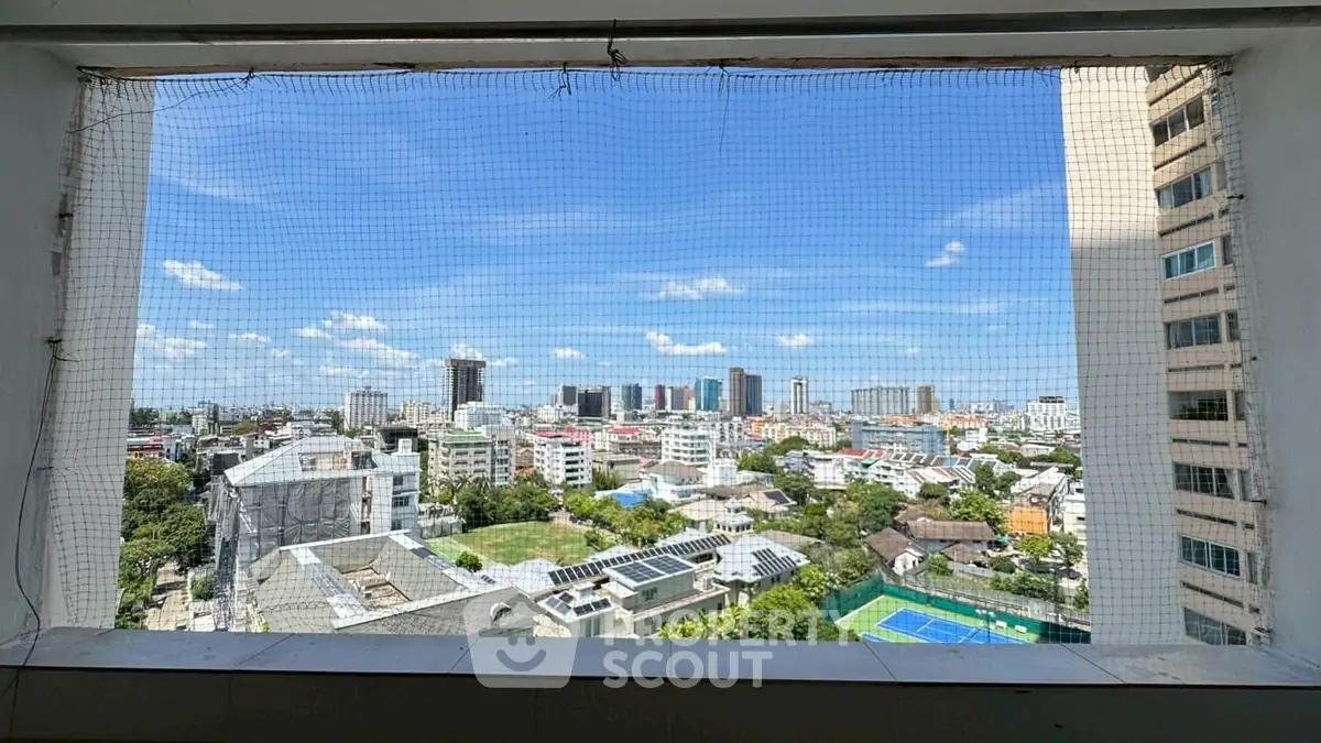 Stunning cityscape view from high-rise building window with clear blue sky.