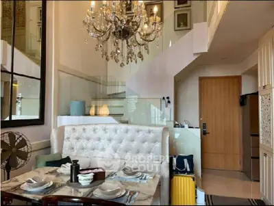 Luxurious living room with elegant chandelier and stylish dining area in modern apartment.