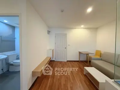 Modern living room with wooden flooring and adjacent bathroom