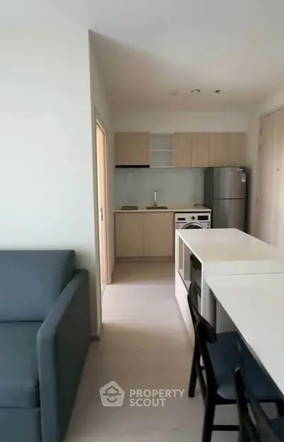 Modern apartment kitchen with sleek cabinetry and cozy living area