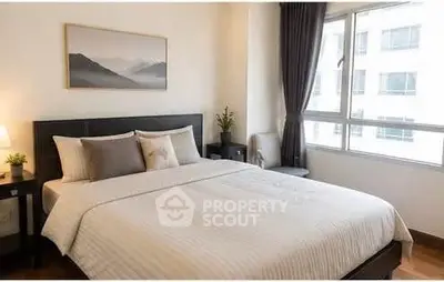 Cozy bedroom with large window and elegant decor in modern apartment.