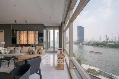 Luxurious living room with stunning river view and modern decor in high-rise apartment.