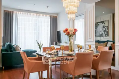 Luxurious dining area with elegant chandelier and modern decor in a spacious living room.