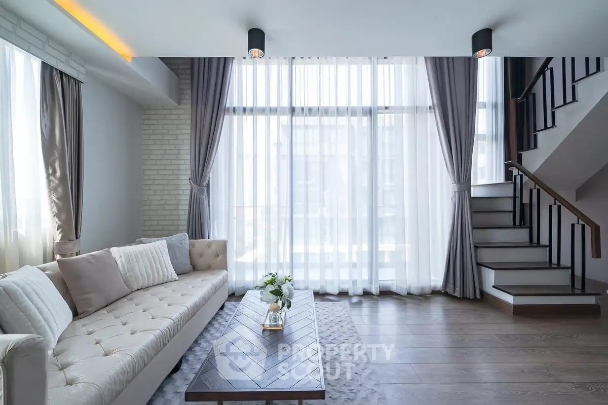Elegant living room with modern decor and large windows