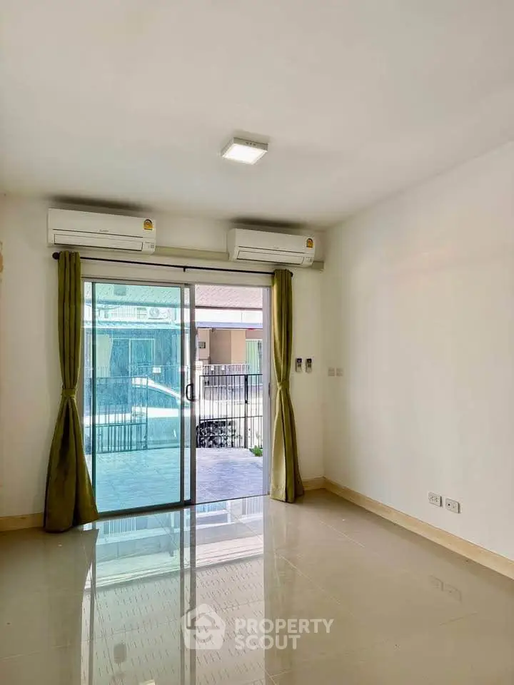 Bright living room with air conditioning and balcony access in modern apartment.