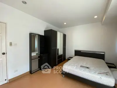 Spacious bedroom with modern furniture and ample natural light