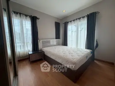 Spacious bedroom with large windows and modern decor, perfect for natural light lovers.